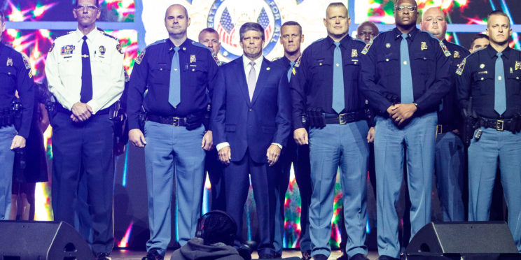 Center, Hal Taylor, Secretary of Law Enforcement of the Alabama Law Enforcement Agency (ALEA) stands with 150 law enforcement officers on stage during the 2022 Faulkner Benefit Dinner.