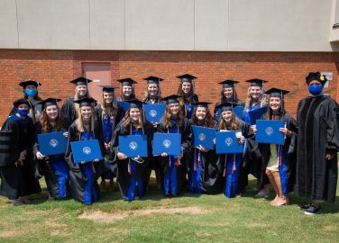 Speech-Language Pathology graduates and professors pose after the commencement ceremony. Back row l-r: Dr. Leah Fullman, Elizabeth Meadows, Ragan Knotts, Mollie Carter, Brittany Cooper, Kelli Mallett, Kandice Cleckler, Kelsie Ulrich. Front row l-r: Dr. Amy Ogburn, Caitlyn Barnes, Emily Hadley, Tabitha Hendrick, Kristin Williams, Kaitlyn Hale, Lindsey Mullino, Hailey Loria, Dr. Cara Tyson.