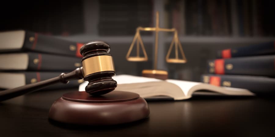 judges-gavel-with-justice-scale-and-law-books-in-background