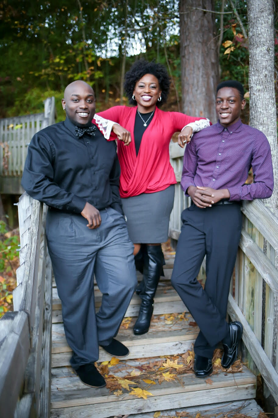 Christa Richardson, center, with her two sons pose for a picture on a wooden outdoor staircase.