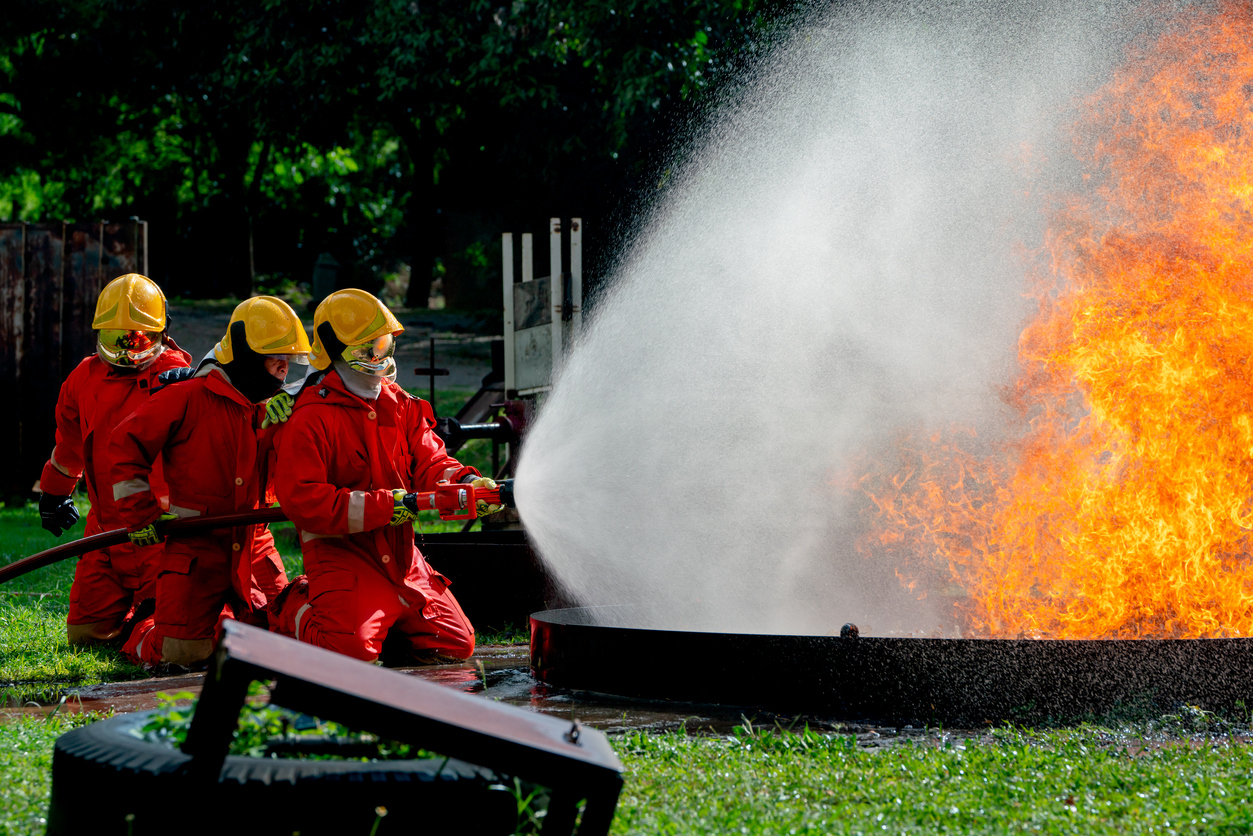 Side view of firefighters support to use sprinkler to create water curtain to protect team from fire and also use to get rid fire.
