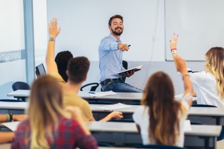 College students asking professor questions.