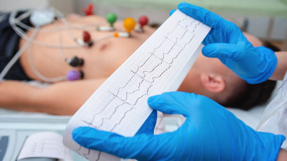 Photo of a doctor reading an EKG with a patient in the background