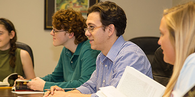 A teacher and students discussing a book in a classroom