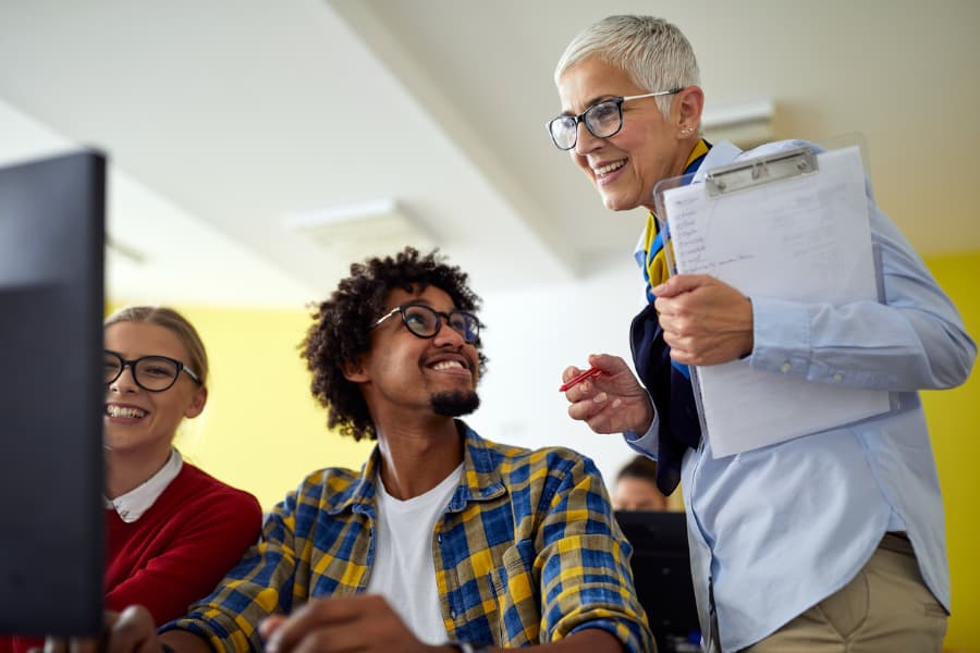 Professor helps students at computer