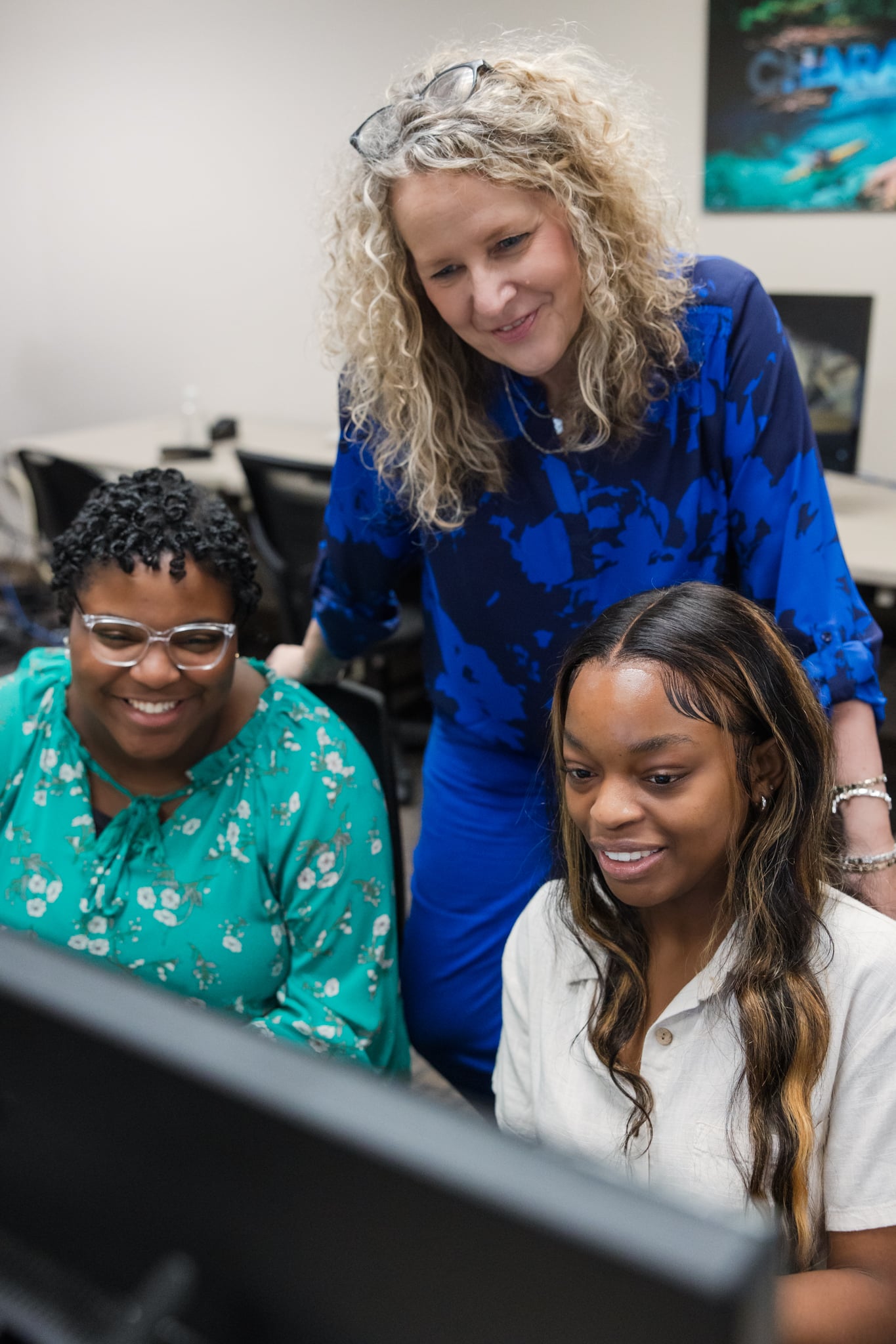 Professor Natasha Kasarjian helping two information systems students at a computer
