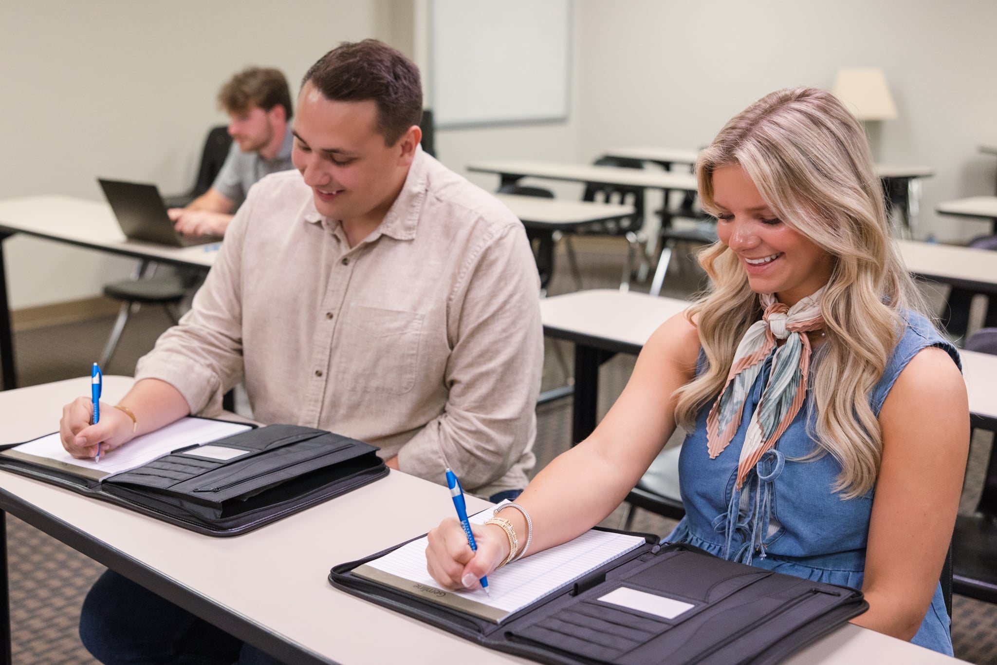Business administration students Tucker Clifton and Madelyn Stanfield taking notes in class