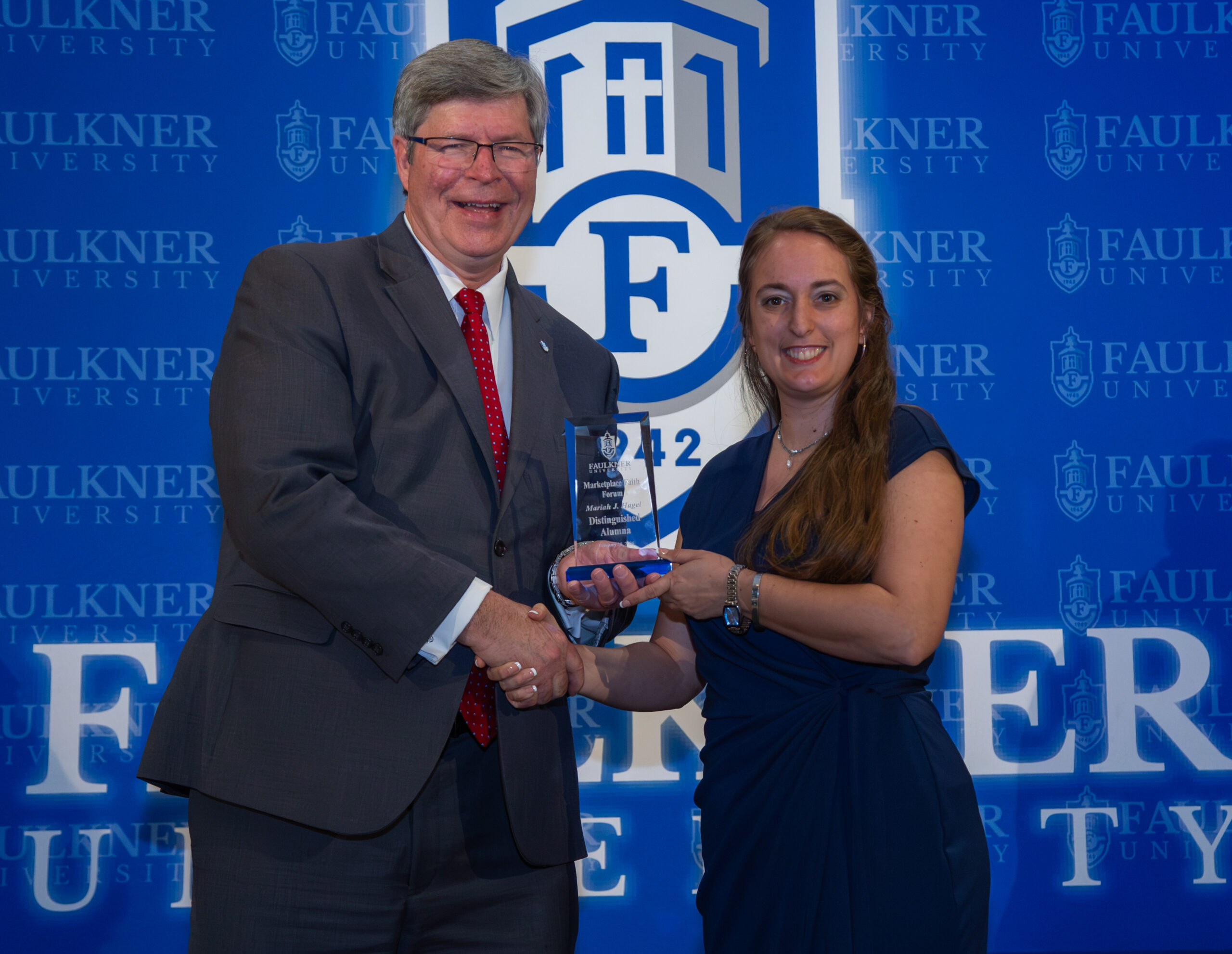 President Mitch Henry presents the Distinguished Alumna Award to Moriah Hagel.