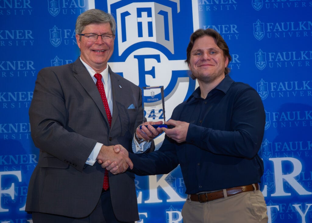 President Mitch Henry presents the Accomplished Alumnus Award to Jonah Dawes.