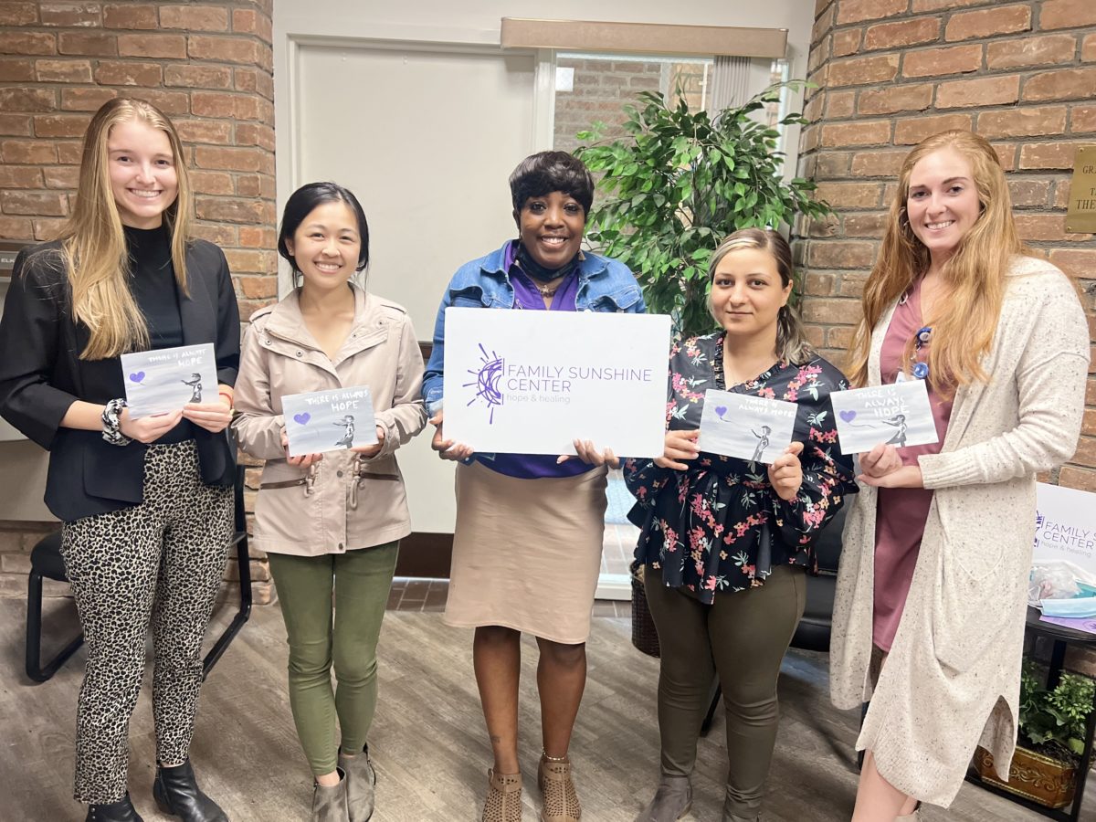 l-r, College of Health students, Jenna Bazil, Michelle Liu, Jessica Witherspoon with Family Sunshine Center, Tevri Tayip and Hannah Beckett pose with their artwork from Painting with a Purpose event. 