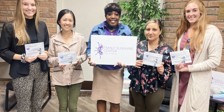 l-r, College of Health students, Jenna Bazil, Michelle Liu, Jessica Witherspoon with Family Sunshine Center, Tevri Tayip and Hannah Beckett pose with their artwork from Painting with a Purpose event.