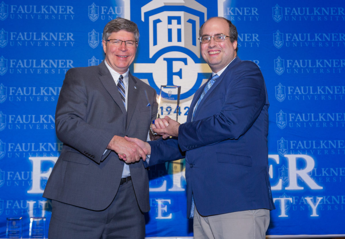 President Mitch Henry awards Justin Rudder with the Distinguished Alumnus Award. 