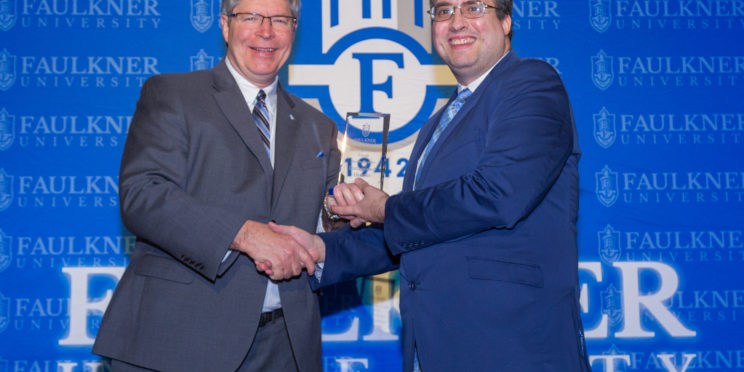 President Mitch Henry awards Justin Rudder with the Distinguished Alumnus Award.