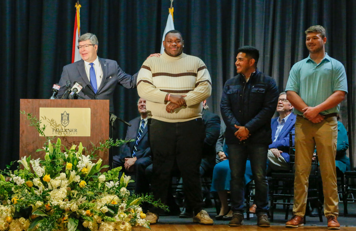 Mitch Henry on stage with Faulkner University students Quanterio Stokes, Jonathan Villa, and Travis Pate.