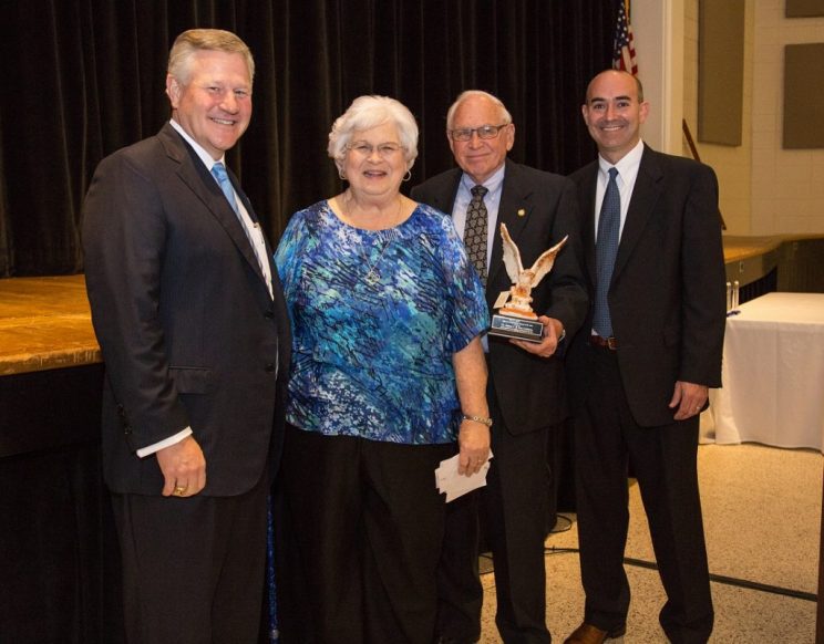 Center, Sue and Jim Crabtree are presented with the 2018 Alumni of the Year award by President Mike Williams and Alumni Director Adam Donaldson.