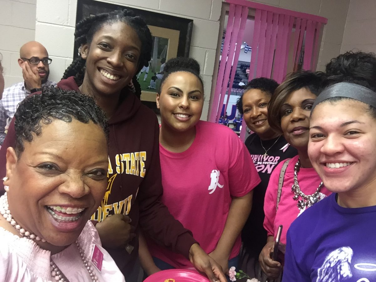 Breast Cancer survivors pose with the Faulkner Women's Basketball team after their PinkOut game in 2020.