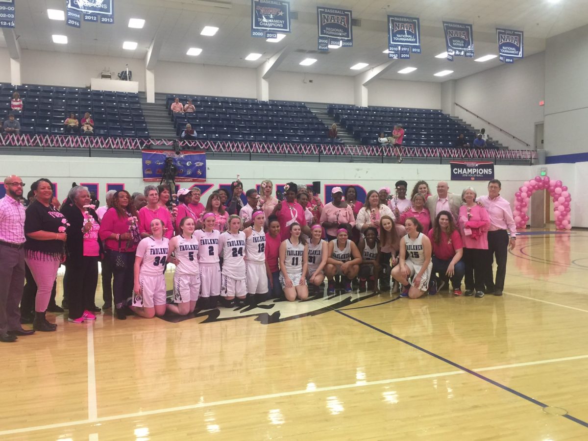 Breast Cancer survivors pose with the Faulkner Women's Basketball team during their PinkOut game in 2020.