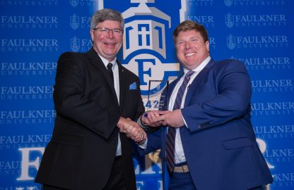 Ben Kissinger receives the Accomplished Alumnus Award from President Mitch Henry.
