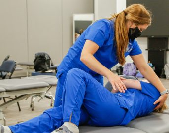Physical Therapy students practice during a lab session. They have earned accreditation.
