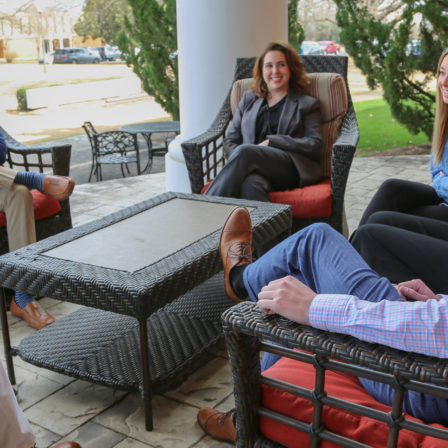 Students meeting on the back patio of the business building