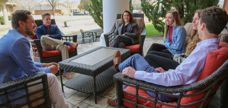 Students meeting on the back patio of the business building