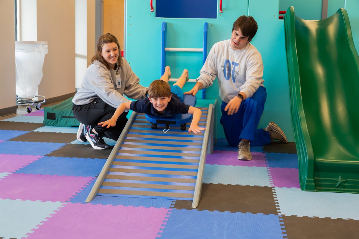 A young patient enjoys his therapy inside the clinic's Pediatric Gym.