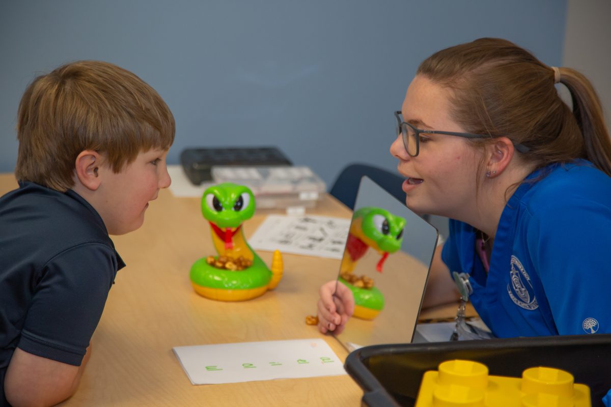 A young patient works on his speech therapy inside the clinic.