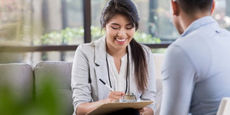 Clinical psychologist taking notes during patient appointment