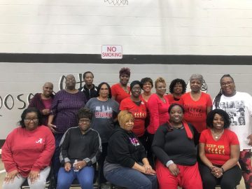 Cyd Howard, front row, sits among women with the nonprofit KOSQS, which aids the underserved in Birmingham.