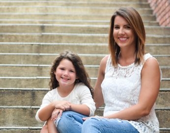 Meghan Harris and daughter, Ollie sit on concrete steps.