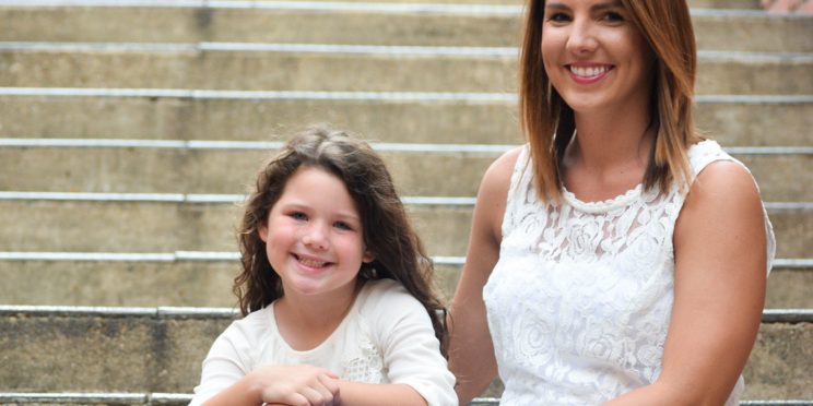 Meghan Harris and daughter, Ollie sit on concrete steps.