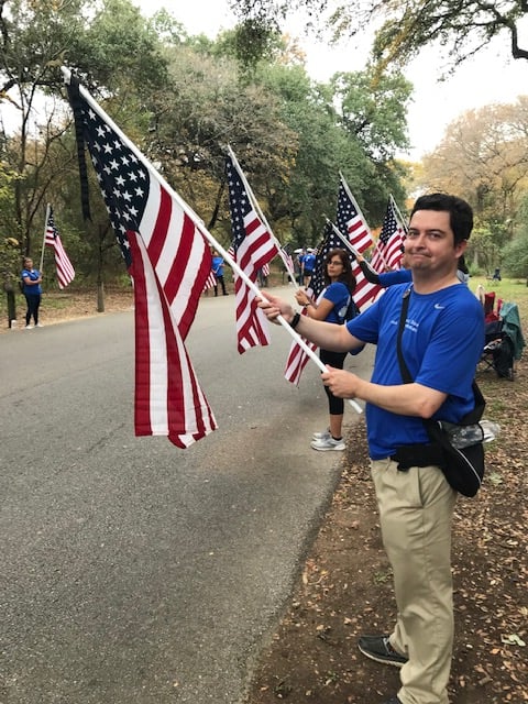 David Brookshire holds a flag in honor of Laurie's brother, SSG Michael Hosey.