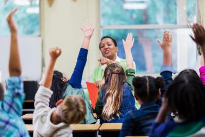 Elementary School Teacher And Students In Classroom