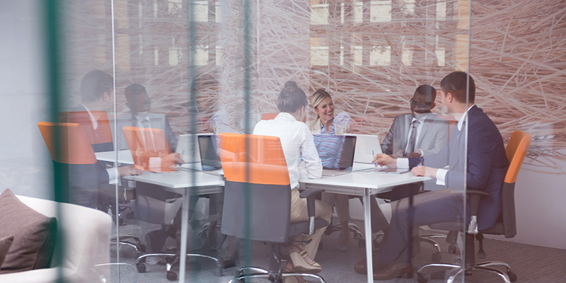 ExecutiveGlass Young executives sitting at a conference table.