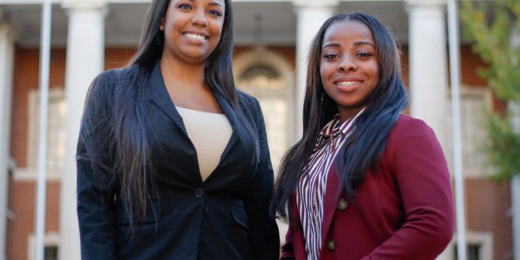 Faulkner Law graduate Aigner Kolom, left poses with Faulkner Law student Iesha Brooks in front of Montgomery City Hall.