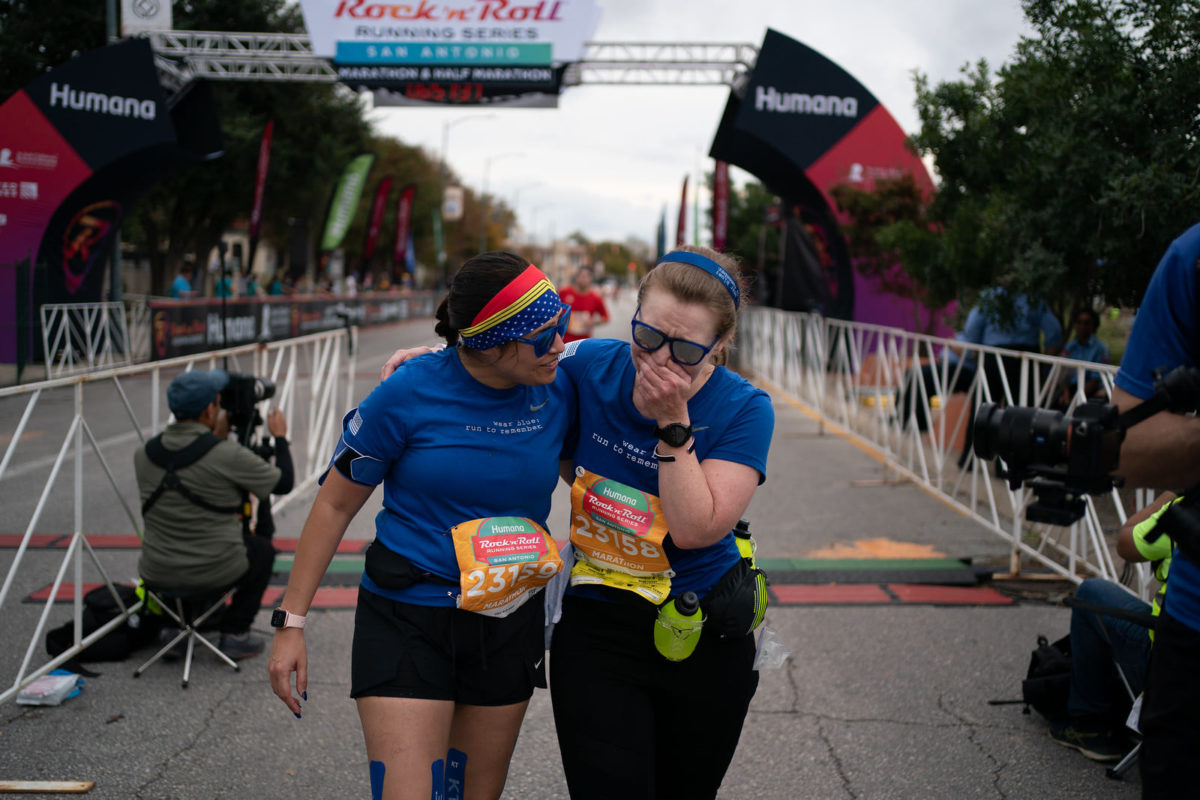 Overcome with emotion, Laurie Brookshire, right, is comforted by another runner after both cross the finish line of the Rock&Roll Marathon.