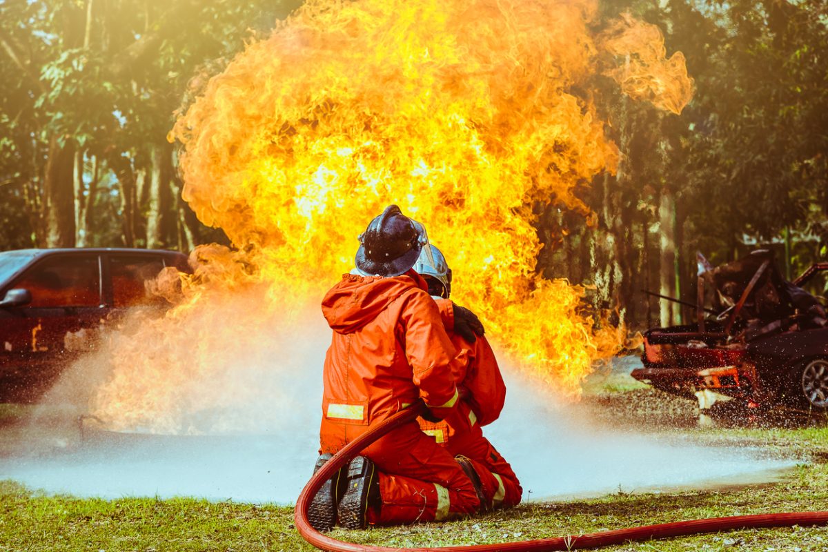 Firefighters use high-pressure water spray to extinguish rural fire