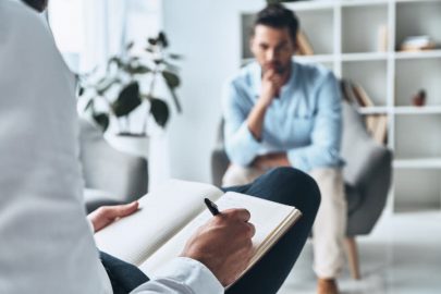 Psychologist Writing Notes While Working With Patient