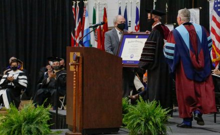 Dale Kirkland, left and President Mike Williams, right confer an honorary Doctorate of Humane Letters to David Shannon, center.