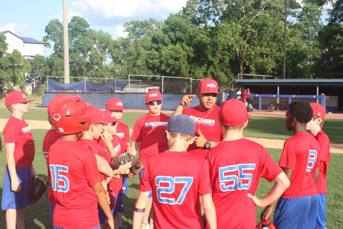 Jonathan Villa talks with a group of children with Anchor baseball.