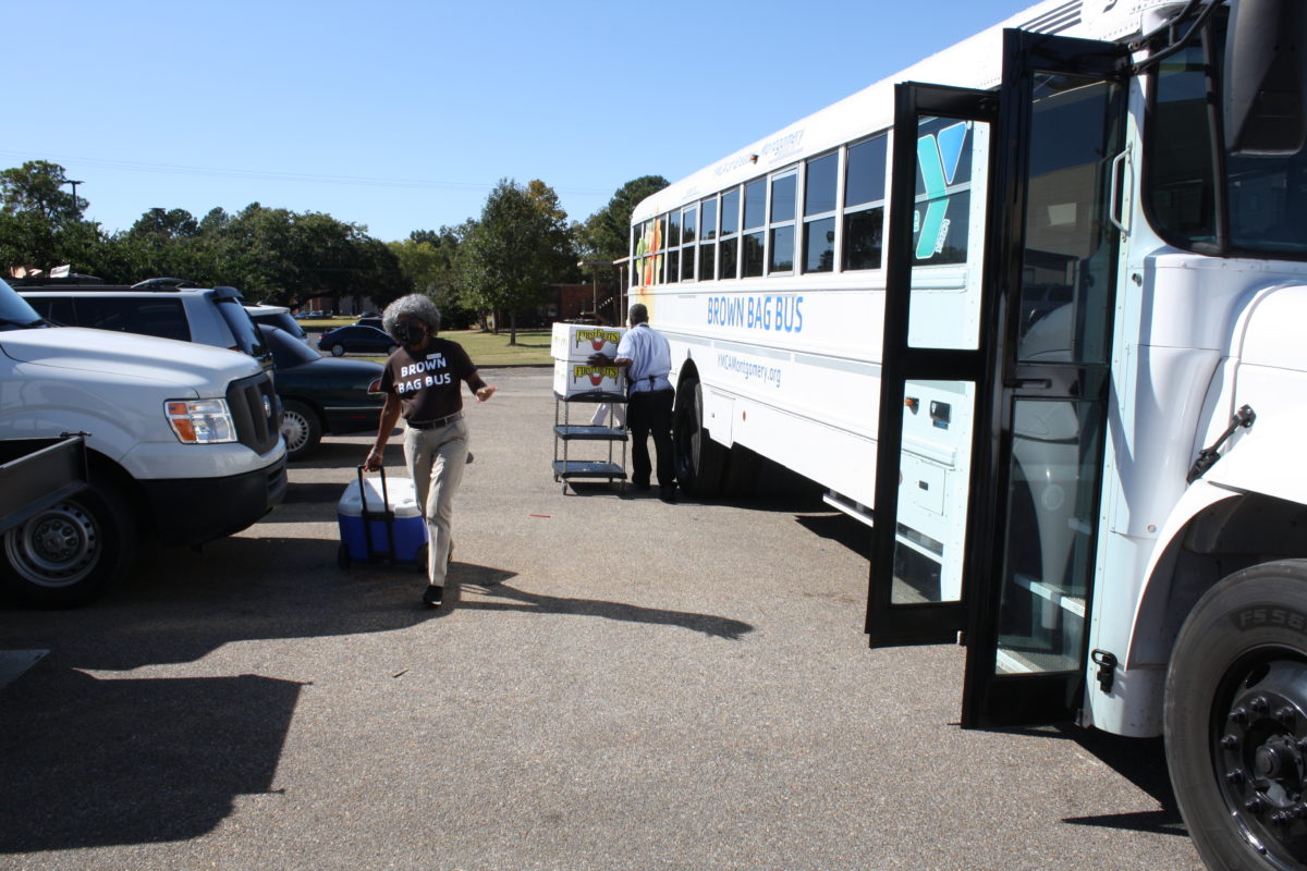 Team members of Culinary Management help load boxed lunches onto the YMCA's Brown Bag Bus. 