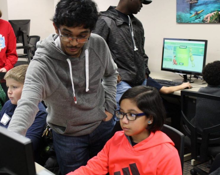 Javan Rampersad helps a fifth-grade student code as a volunteer mentor for a Day of Coding, an annual event at Faulkner, which allows Computer Science majors to introduce basic coding skills to students from area schools.