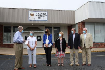 Center, Dr. Leslie Cowell stands with members of the Montgomery Rotary Club.