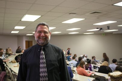 Franklin "Buddy" Renahan is an adoption family counselor. He stands in an auditorium full of students ready to speak during the Marketplace Faith Friday Forums 2021.
