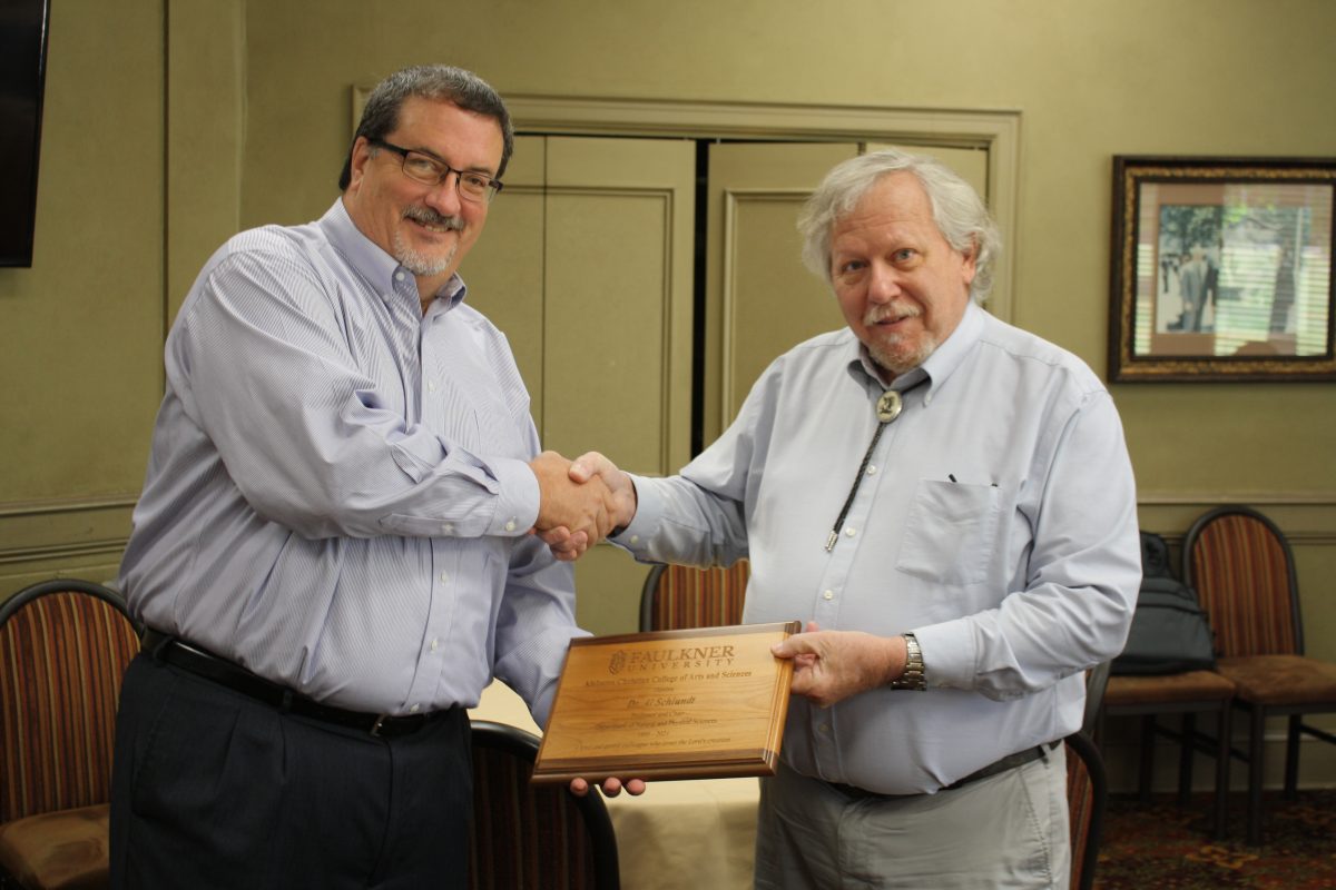 l-r Dr. Jeff Arrington shakes hands and presents a plaque to Dr. Al Schlundt at his retirement ceremony in April. He served as a biologist and an educator.  