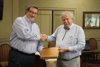 l-r Dr. Jeff Arrington shakes hands and presents a plaque to Dr. Al Schlundt at his retirement ceremony in April. He served as a biologist and an educator.