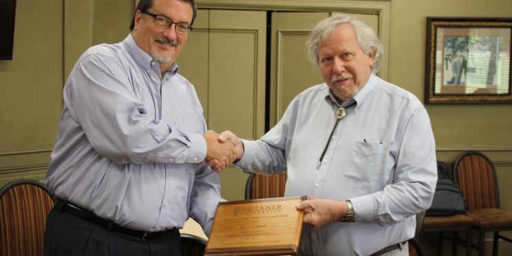 l-r Dr. Jeff Arrington shakes hands and presents a plaque to Dr. Al Schlundt at his retirement ceremony in April. He served as a biologist and an educator.