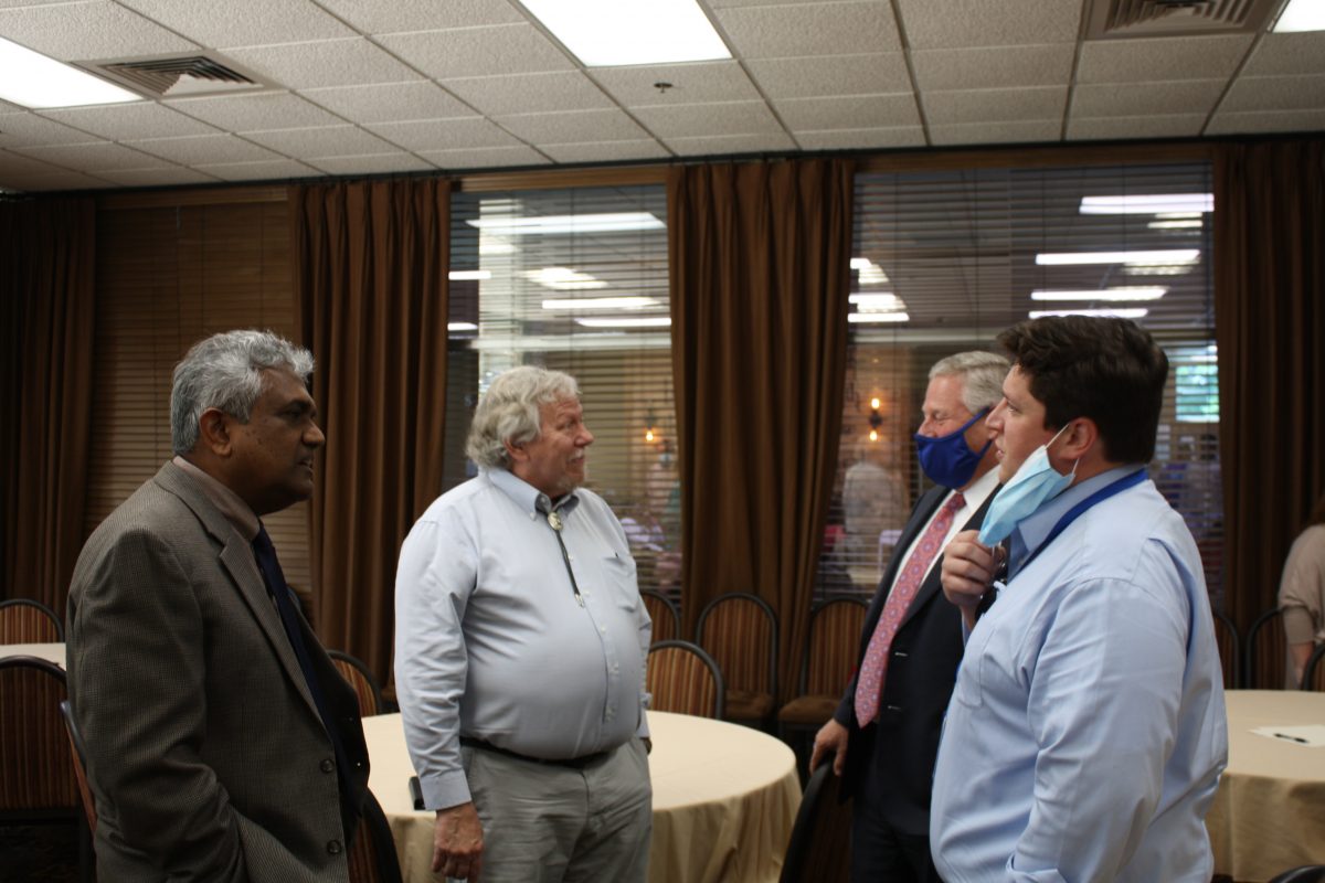 l-r Dr. Dave Rampersad, Dr. Al Schlundt, President Mike Williams and Wesley Schlundt chat during Al Schlundt's retirement ceremony. Schlundt served as a biologist and an educator.