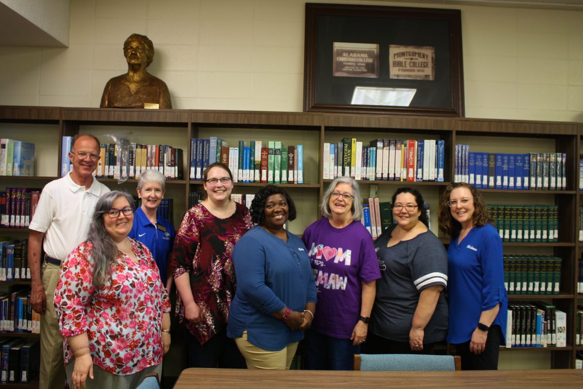 Barbara Kelly stands among her colleagues at the Gus Nichols Library.
