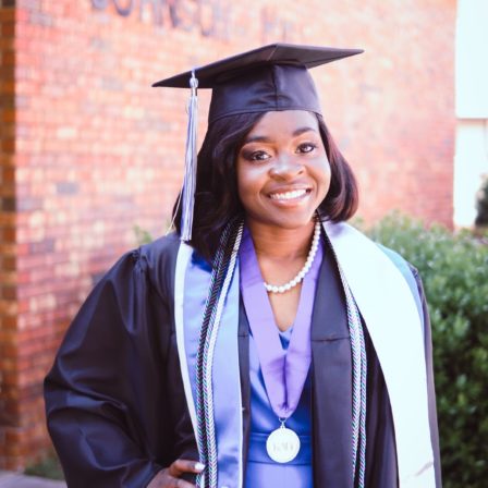 Zanesha Rhodes poses in her graduation regalia outside Johnson Hall, where she spent much of her time as a College of Education student.